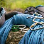 Close up Used equipment for climbing where the rope carbines and climbing slippers lie on a rock